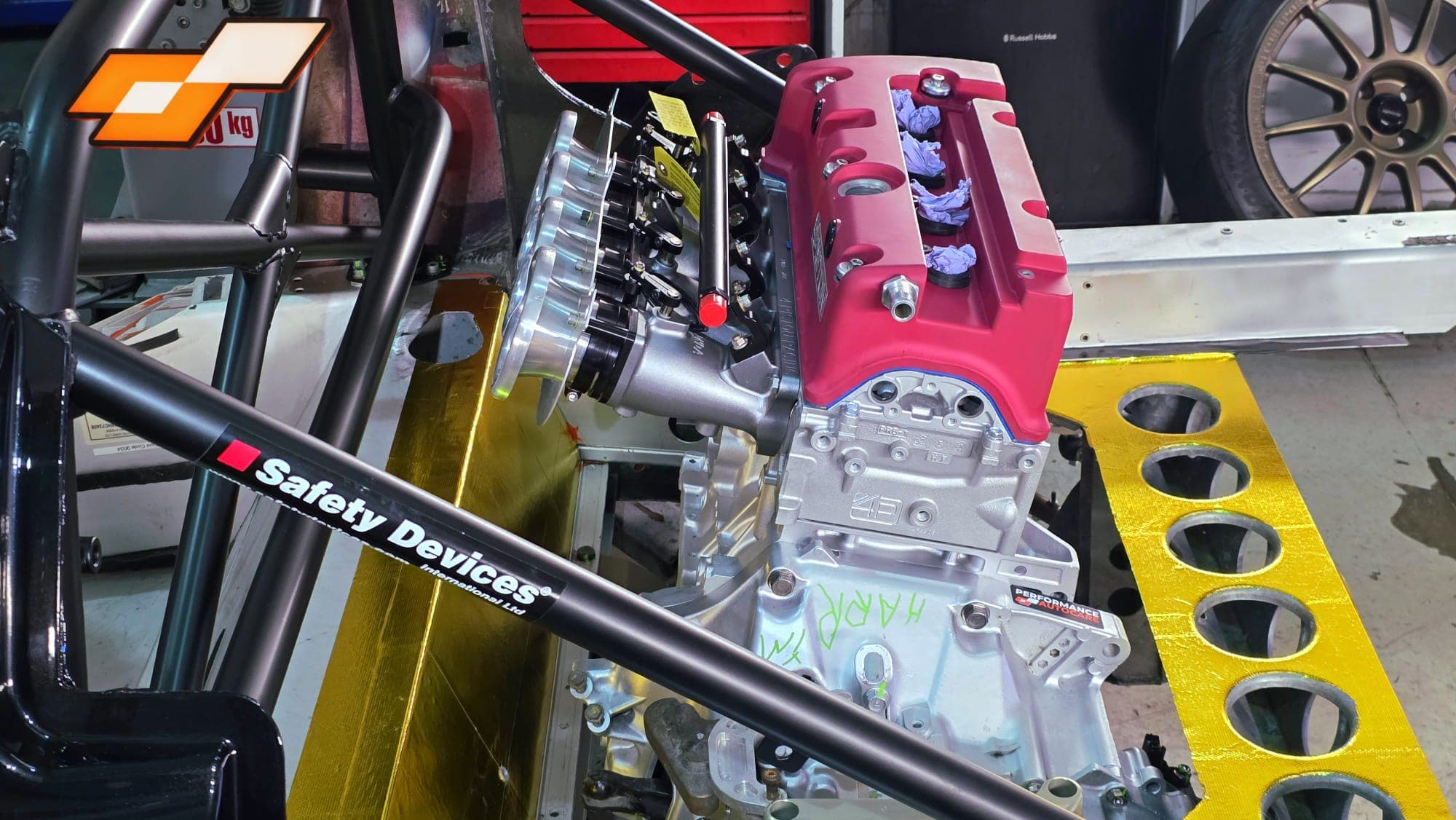 Close-up of the Honda K-series engine block and Individual Throttle Bodies with Safety Devices roll cage bar